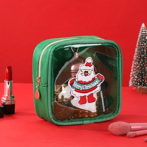 Detail of green makeup bag with Santa embroidery and gold zipper in Christmas scene
