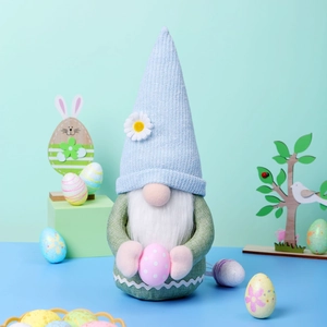 Détail d'un gnome de Pâques bleu clair tenant un œuf à pois roses pour décoration