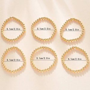 Detail view of 6-piece golden beaded bracelet set with 5.1cm diameter measurement labels