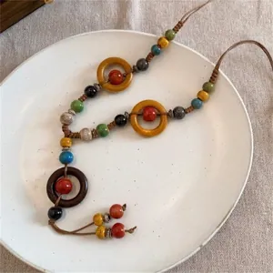 Détail de perles en bois colorées et d'un pompon sur un collier bohème de style ethnique
