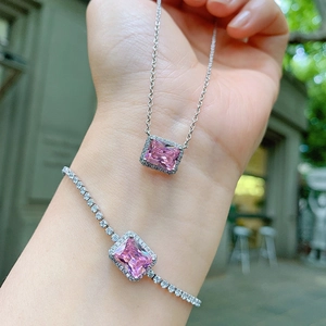 Detail of pink zircon jewelry set with square pendants on model in outdoor setting
