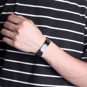 Close-up of 15mm wide black polished curved plate bracelet worn on man's wrist