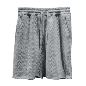 Détail du short en maille gris avec motif jacquard texturé et taille élastique à cordon de serrage