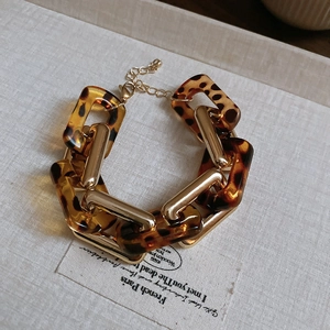 Dettaglio bracciale con maglie in resina leopardata e chiusura a moschettone
