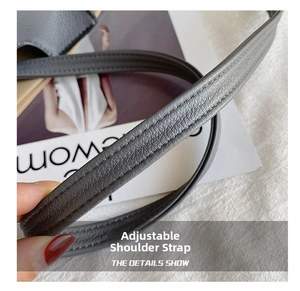 Detailed macro view of the grey leather adjustable shoulder strap with double stitching