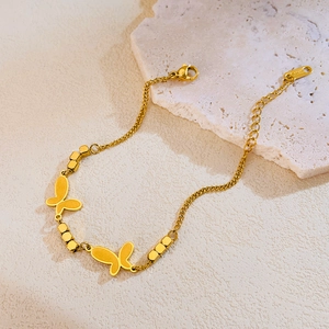 Détail du bracelet papillon en acier inoxydable doré avec perles et fermoir mousqueton