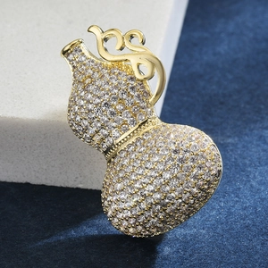 Sparkling crystal pavé calabash brooch in gold plating on elegant velvet background