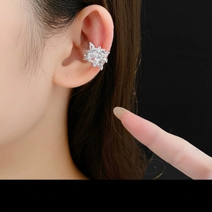Elegant silver flower ear cuff with sparkling zircons on model's ear, luxury design