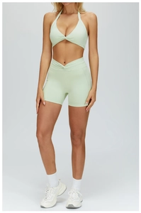 Detail of mint green yoga set featuring halter twisted sports bra and V-cross high waist shorts