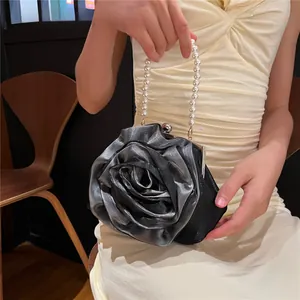 Close-up of black satin rose detail and white pearl handle on this vintage bridal bag