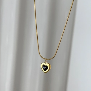 Elegant gold snake chain necklace with heart pendant and black enamel inlay accent