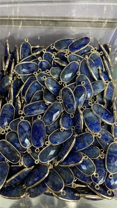 Close-up of faceted lapis lazuli oval connectors with gold plating for jewelry making