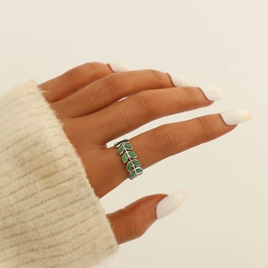 Close-up of adjustable leaf-shaped ring with green enamel finish on woman's finger