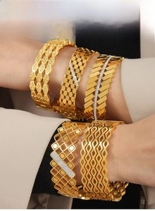 Close-up of luxury gold-plated hollow bangles with geometric patterns and zircon stones