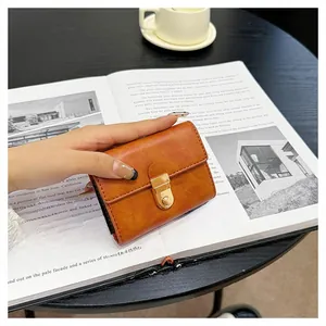 Close-up of brown vintage leather wallet with gold snap button and stitched details