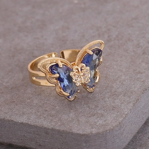 Detailed close-up of 18K gold butterfly ring featuring blue gradient crystal and diamonds