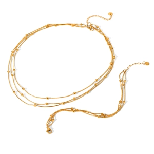 Layered gold stainless steel necklace with bead chain design on a white background