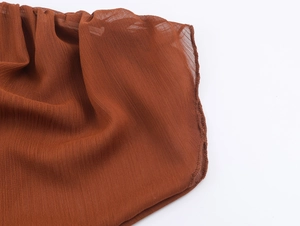 Nahaufnahme von dunkelbraunem Chiffonstoff mit feiner Struktur und sauberer Saumverarbeitung
