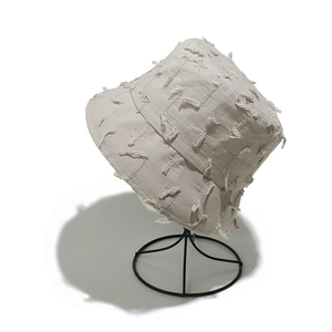 Detailed close-up of beige cotton bucket hat featuring vintage distressed fringe textures