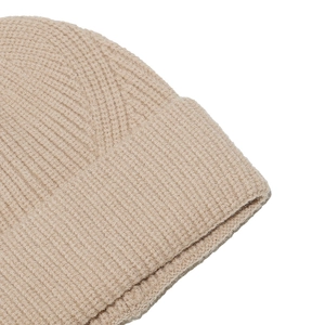Detailed close-up of light brown ribbed knit beanie showing soft texture and thick stitching