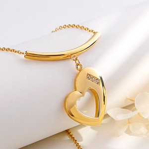 Golden heart pendant necklace with three diamonds on O-chain against floral background