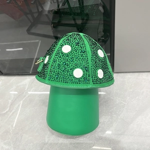 Detailed view of green mushroom-shaped bag with sparkling rhinestones and white polka dots