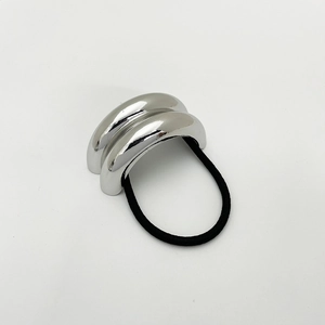 Detail of a silver metallic curved accent on a black elastic hair tie for women