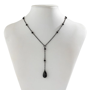 Detail of gothic Y-shaped black necklace with faceted beads and teardrop crystal pendant