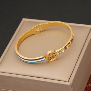 Macro detail of gold tree of life bangle with blue evil eye enamel and jewelry box