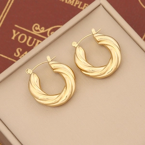 Minimalist gold twisted hoop earrings with irregular geometric metal texture and shiny finish