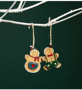 Detailed view of hand-painted wooden gingerbread man ornaments hanging on white branches
