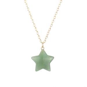 Macro detail of natural green aventurine star pendant with thin gold link chain