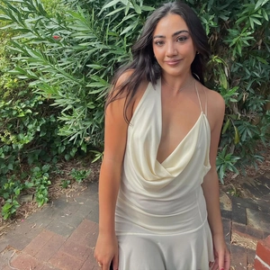 Detail of the cowl neck design and draped cream-colored fabric on a backless dress