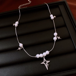 Gros plan du collier de perles avec pendentifs étoiles sur un plateau à bijoux noir