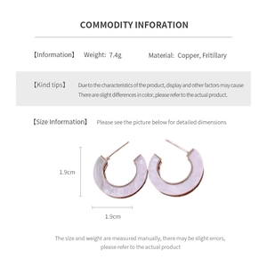 Detail of C-shaped rose gold earrings with white fritillary inlay and sizing data