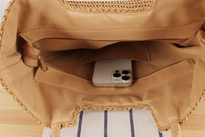 Detailed interior of a woven straw bag featuring khaki lining with functional pockets