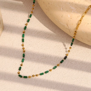Detailed view of 18K gold-plated beaded necklace with green malachite cylinder stones