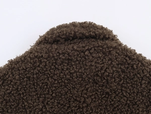 Close-up of deep brown Sherpa fleece fabric showing dense curly texture for winter jackets