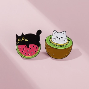 Detailed view of cute enamel cat pins featuring watermelon and kiwi fruit themes