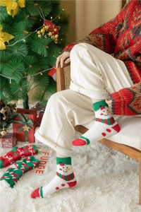 Close-up of thick coral fleece Christmas socks with snowman pattern in a festive setting