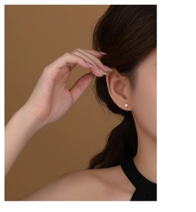 Close-up of elegant s925 silver stud earring with round zircon on a golden base
