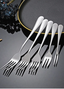 Polished stainless steel forks set on a black reflective surface with elegant plating