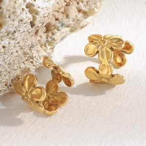 Vue détaillée des boucles d'oreilles clips fleurs plaquées or 18 carats sur pierre