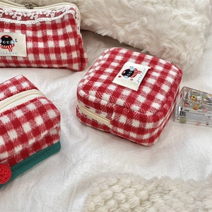 Close-up of red and white plaid knit storage bag with cute black cat patch detail