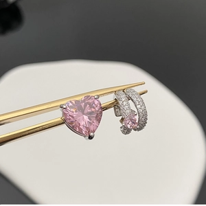 Vue rapprochée de boucles d'oreilles en argent avec cristaux en cœur rose et pince