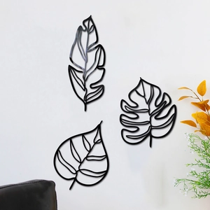 Lot de 3 décorations murales en métal noir avec feuilles creuses sur mur blanc