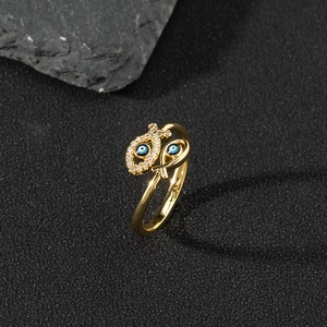 Macro shot of gold-plated fish ring with zircon paving and blue evil eye enamel details