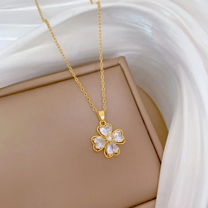 Macro shot of gold four-leaf clover pendant necklace with heart-shaped cubic zirconia