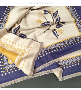 Detail of soft winter scarf with navy yellow floral print and elegant long fringes