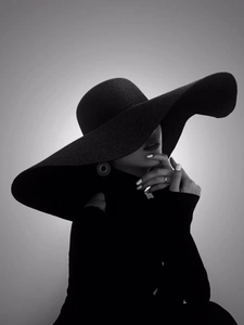 Detail of elegant black wide brim straw hat with woven texture for sun protection